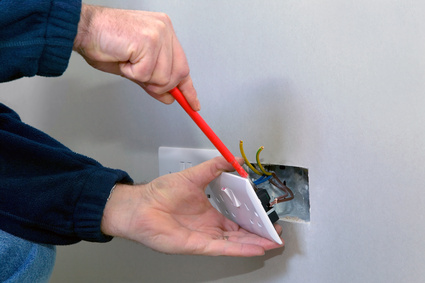 The hands of an electrician installing a power socket Installation in Paget